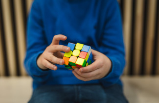 Nuori ratkoo rubikin kuutiota.
