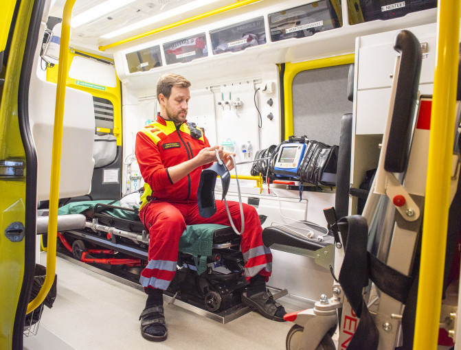 Ensihoitaja huoltaa välineitä ambulanssissa Ensihoitaja huoltaa välineitä ambulanssissa