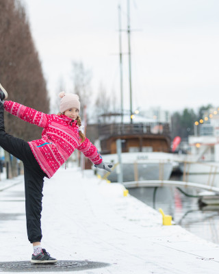 Tyttö liikkumassa talvisessa kaupunkimaisemassa.