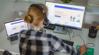 Ammattilainen istuu tietokoneella.