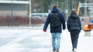 Kaksi henkilöä kävelevät pihalla. Kaksi henkilöä kävelevät pihalla.