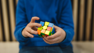 Nuori ratkoo rubikin kuutiota. Nuori ratkoo rubikin kuutiota.