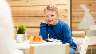 Lapsi lukee lehteä hedelmäkulhon vieressä. Lapsi lukee lehteä hedelmäkulhon vieressä.