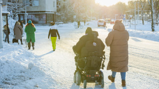 Pyörätuolia käyttävä henkilö ja avustaja kaupungissa. Pyörätuolia käyttävä henkilö ja avustaja kaupungissa.
